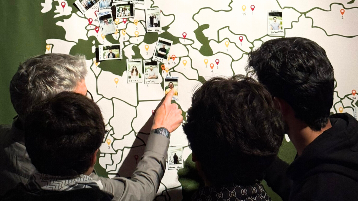 Students point their fingers at a world map.