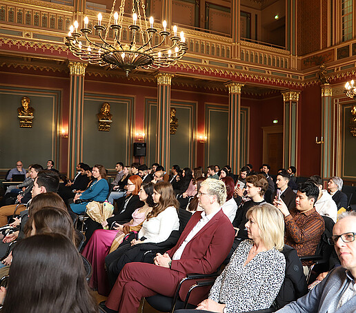 Guests at the certificate ceremony on rows of chairs in the Bürgersaal