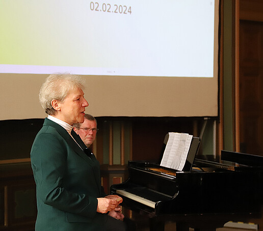 Ellen Leuschner in front of the audience, in the background Mr. Leipert at the piano.
