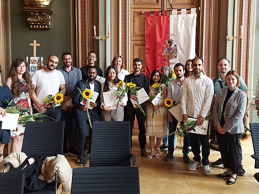 The graduates of the DSH course of the Studienkolleg stand in the Bürgersaal of the Zittau town hall to celebrate their degrees.